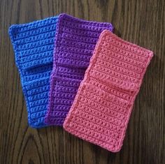 three crocheted pouches sitting on top of a wooden table next to each other