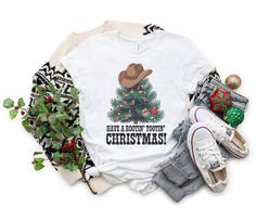 Get ready for a rootin' tootin' Christmas with a Western twist! 🤠🎄 This festive tee features a Christmas tree topped with a cowboy hat and decorated with boots and lassos--perfect for adding some country flair to your holiday celebrations. Ideal for anyone who loves cowboys and the spirit of Christmas, this t-shirt is a fun and unique way to spread holiday cheer. *Soft and breathable fabric, great for comfort during all your holiday festivities. *Unisex fit, making it a fantastic Christmas gift for both men and women who appreciate Western charm. *Playful cowboy-themed Christmas tree design, perfect for family gatherings, holiday parties, or gifting to country-lovin' friends. *Available in multiple sizes for everyone in the family--create adorable matching outfits for family photos! *Vib Christmas Tee Shirts Western, Matching Outfits For Family, Outfits For Family Photos, Rootin Tootin, Christmas Western, Christmas Tree Tops, Cowboy Christmas, Themed Christmas, Cowgirl Cowboy