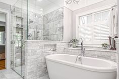 a white bath tub sitting next to a walk in shower