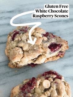 two gluten free white chocolate raspberry scones on a marble surface