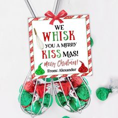 a christmas ornament hanging from a wire with candy in it and a sign that says, we whisk you a merry kissmas