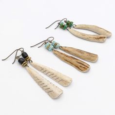 three pairs of wooden earrings with turquoise beads on them, hanging from earwires