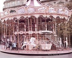 an old fashioned merry go round in front of a building