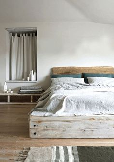 a bed room with a neatly made bed next to a dresser and window sill