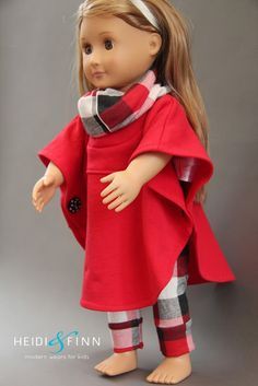 a doll with blonde hair wearing a red dress and plaid leggings, standing in front of a gray background