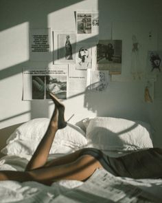 a woman laying on top of a bed in a room with papers all over her