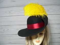 "This cavalier hat is inspired by Puss n Boots. This is a black woolen felt cavalier hat with a burgundy satin band and yellow ostrich feathers. This hat is 22.5\" for the inside circumference but does have a built-in hat sizer. I'm sorry, I cannot make the inside circumference bigger. PLEASE MEASURE YOUR HEAD TO MAKE SURE THE HAT WILL FIT. I do not take returns and all sales are final. thank you I ship Priority mail. I ship many times a week. If you need your item quicker let me know your zip code and I can figure shipping rates for you. Please let me know if you have any questions All sales are FINAL, no returns or exchanges please keep this in mind before purchasing." Cavalier Hat, Musketeer Hat, Go Dog Go, Black Pirate, Pirate Hat, Pirate Hats, Halloween Black, Costume Hats, Ostrich Feathers