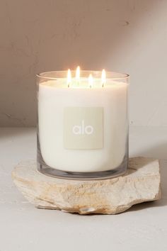 a white candle sitting on top of a rock