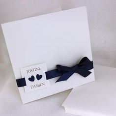 a white card with a blue bow on it