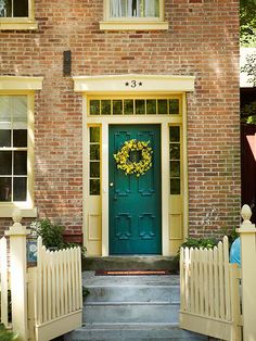 a green front door with a wreath on it