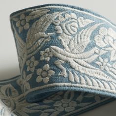 a blue and white floral design on a light blue ribbon with silver trimmings