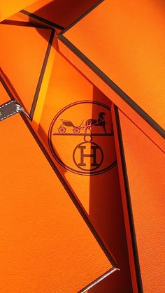 an orange umbrella with the emblem of a car on it's side and shadow