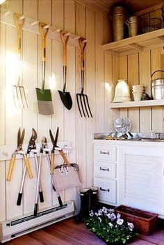 there are many gardening utensils hanging on the wall