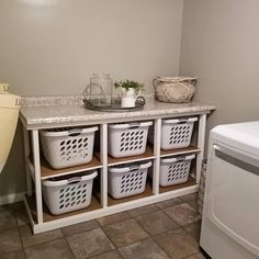 a washer and dryer sitting next to each other in a room with tile flooring