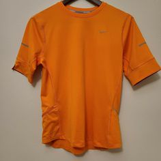 Nike Running Dri-Fit Womens Short Sleeve Shirt This awesome top has two pockets, one open and one zipper pocket. Size: Medium Color: Orange Sporty Orange Short Sleeve Shirt, Orange Short Sleeve Tops For Sports, Nike Orange Sports Top, Nike Orange Short Sleeve Tops, Short Sleeve Shirt Women, Nike Running, Dri Fit, Zipper Pocket, Short Sleeve Shirt