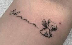 a small black and white tattoo of a dog on the leg with a tail flying through the air