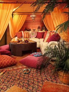 a living room with orange drapes and pillows