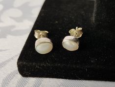 Simple sterling silver mother of pearl stud earrings. They are oval in shape with a raised white dome shaped mother of pearl inlay. They measure 1/3 inches long by 1/4 inches wide. There is a tiny defect in the MOP inlay on one of the earrings, it is about 2.5 mm long. See all the photos. I'll ensure your order is fulfilled as requested. Visit my shop at: newagainclassics.ca -Shipping times are taking longer due to the increase in online shopping- Classic Mother Of Pearl Earrings As Gift, White Cabochon Earrings For Anniversary, Classic Mother Of Pearl Earrings For Gift, Gift White Hallmarked Pearl Earrings, Silver Oval Pearl Earrings, Oval White Pearl Earrings, Silver Pearl Earrings, Mother Of Pearl, Gift, Silver Pearl Earrings With Mother Of Pearl As Gift, Silver Mother Of Pearl Earrings As Gift