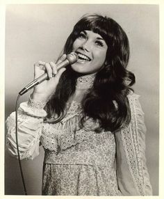 an old photo of a woman singing into a microphone