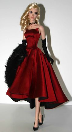 a barbie doll wearing a red dress and black gloves