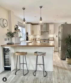 two stools are sitting at the bar in this modern kitchen with stainless steel appliances