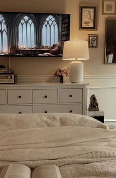 an open book sitting on top of a bed in front of a tv mounted to the wall