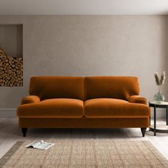 an orange couch sitting on top of a wooden floor