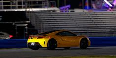 a yellow sports car driving down a race track