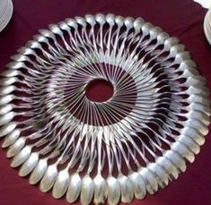 a large silver plate sitting on top of a red tablecloth covered table next to white plates