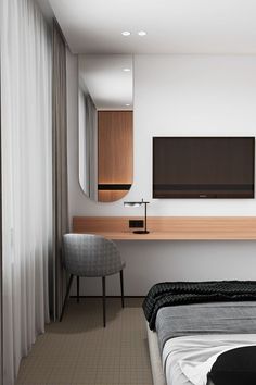 a bedroom with two beds and a flat screen tv mounted on the wall above it