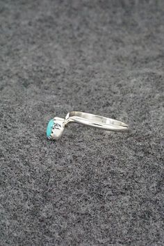 This simple yet elegant turquoise and sterling silver ring was made by Navajo silversmith Hiram Largo. The inside of the band is stamped sterling. (Please note: the stone color may vary slightly from the photos.)Size: 9.5Stone Length: 1/4"Stone Width: 3/16"Free shipping on all orders! We ship with USPS and always include tracking. All orders ship within a day of payment.Returns are accepted up to 30 days after you receive your order. Just send us a message. Our shop offers cash back or store credit. The item must be returned in new condition. Southwestern Sterling Silver Turquoise Ring For Anniversary, Southwestern Style Teardrop Turquoise Ring In Sterling Silver, Southwestern Sterling Silver Rings For Anniversary, Sterling Silver Turquoise Gemstone Promise Ring, Sterling Silver Turquoise Ring For Promise, Teardrop Turquoise Sterling Silver Rings, Southwestern Sterling Silver Teardrop Ring, Silver Turquoise Open Ring For Anniversary, Anniversary Silver Turquoise Open Ring