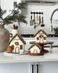 two gingerbread houses are sitting on the kitchen counter