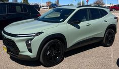 a light green suv parked in a parking lot