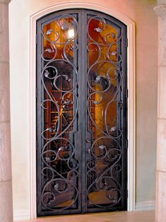 an ornate iron door with glass panels in the center and sidelights on either side