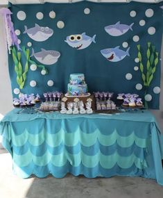 an under the sea themed birthday party with blue and white decorations, fish, and cake