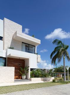 a large white house with palm trees in the background