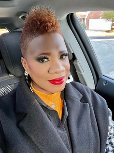 a woman sitting in the back seat of a car with red lipstick on her lips