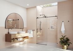 a bathroom with a sink, mirror and shower stall in the corner next to a potted plant