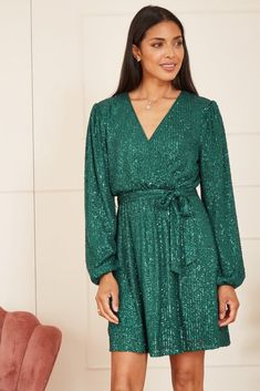 Festive partywear is here. Make an entrance in this Mela Green Sequin Wrap Dress. Incredibly flattering, this wow-factor dress benefits from a wrap around shape, matching sequin tie and long sleeves. Match with silver accessories for an unforgettable look. Shell:100% Polyester, Lining:100% Polyester Hand Wash Length 89cm Sequin Wrap Dress, Statement Clutch, Maxi Bridesmaid Dresses, Shape Matching, Green Sequins, Sequin Mini, Silver Accessories, Long Puff Sleeves, Sequin Mini Dress