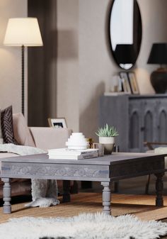 a living room filled with furniture and a mirror on top of the wall next to a coffee table