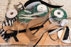 several different types of ribbons and tape on a wooden board with black and white stripes