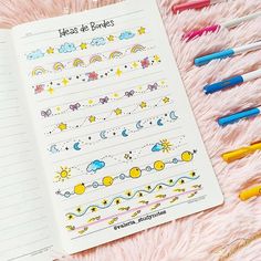 an open notebook with writing on it next to markers and pencils in the shape of rainbows