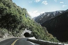 a tunnel in the side of a mountain road