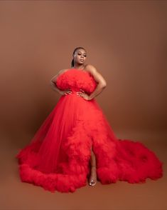 a woman in a red dress posing for the camera with her hands on her hips