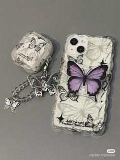 a cell phone case with a butterfly on it and a keychain attached to it