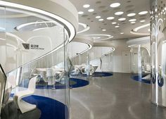 the interior of a modern office with white chairs and blue carpeted flooring is lit by round lights