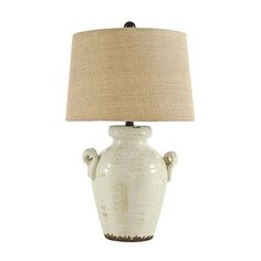 a white ceramic lamp with a beige shade