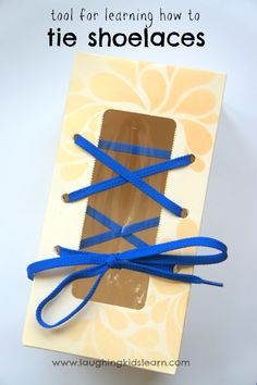 an open shoelace box with blue ribbon tied around it and text overlay that reads tool for learning how to tie shoelaces