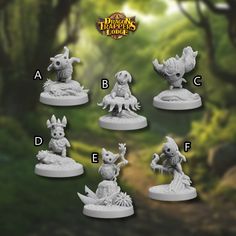 some white plastic figurines sitting on top of each other in front of a forest