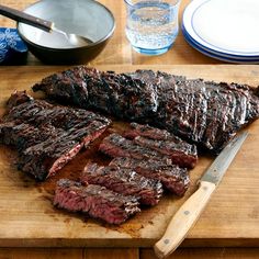 the steak is cut up and ready to be served on the table with other dishes